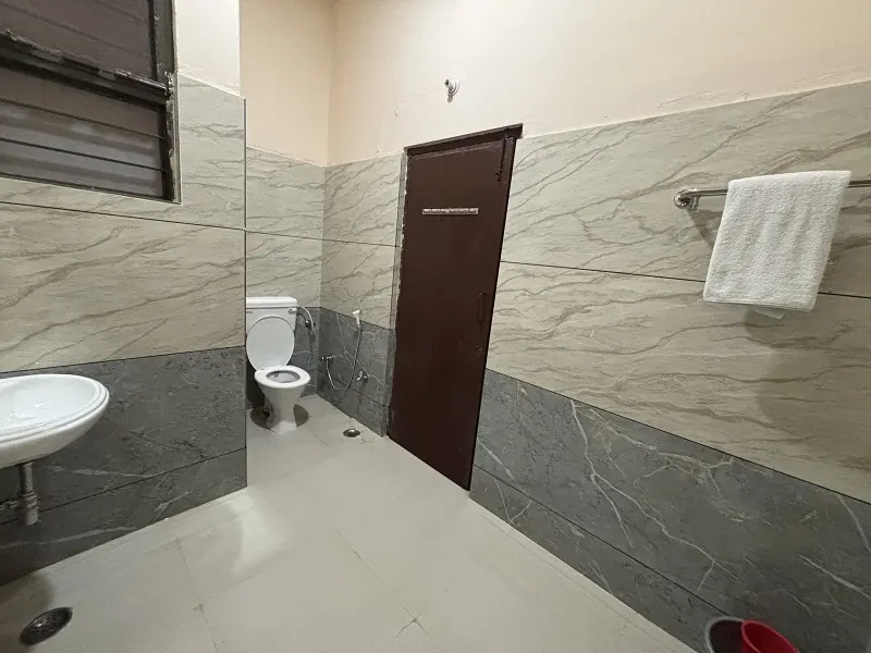 Clean attached bathroom with hot water at Guru Kripa Hotel, Agolai